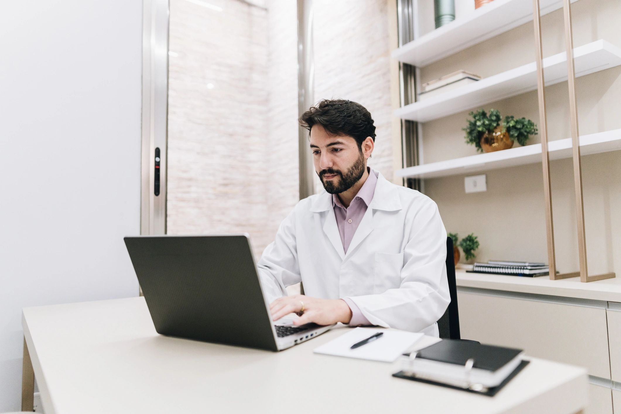 Doctor reviewing information on a laptop in an office