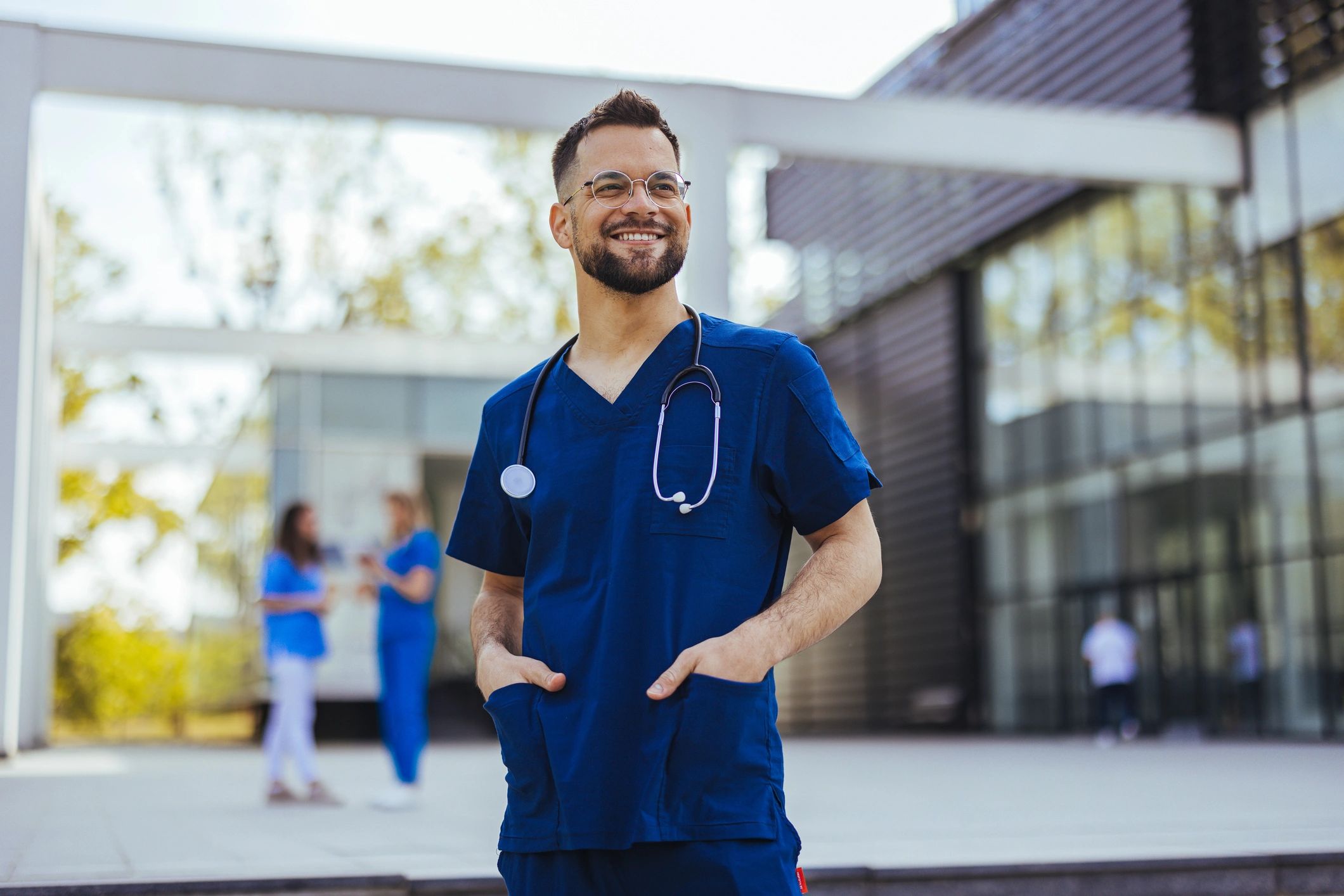 Medical professional standing with arms crossed in a clinic