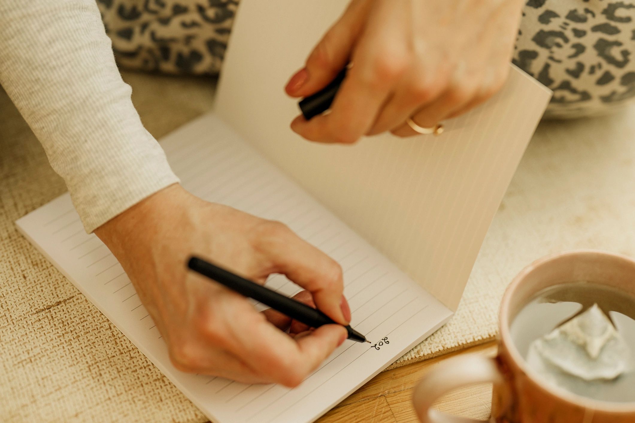 Person writing notes in a notebook at home